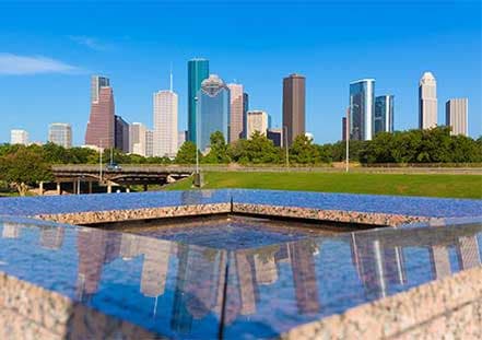 Houston, Texas skyline reflecting in a calm water feature on a sunny day.