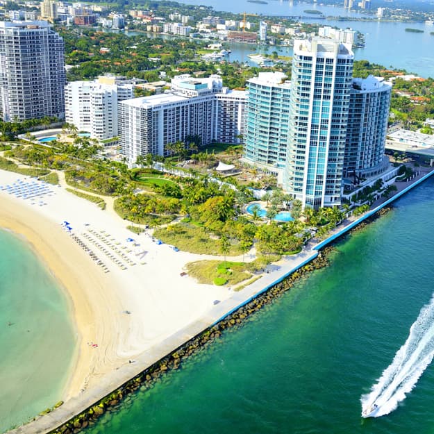 Aerial view of Miami Beach, Florida, showing skyscrapers, sandy beaches, and blue ocean.