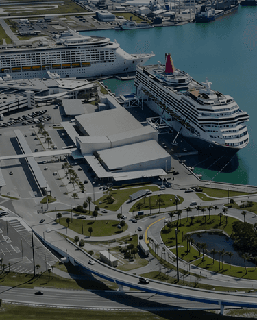 Aerial view of an industrial port with multiple large ships docked and surrounding buildings.