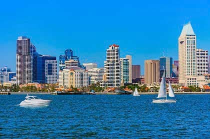 San Diego skyline viewed from the bay, with sailboats and modern buildings.