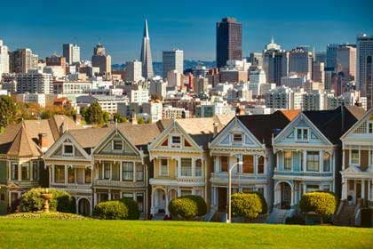 The Painted Ladies Victorian houses in San Francisco with the city skyline behind them.